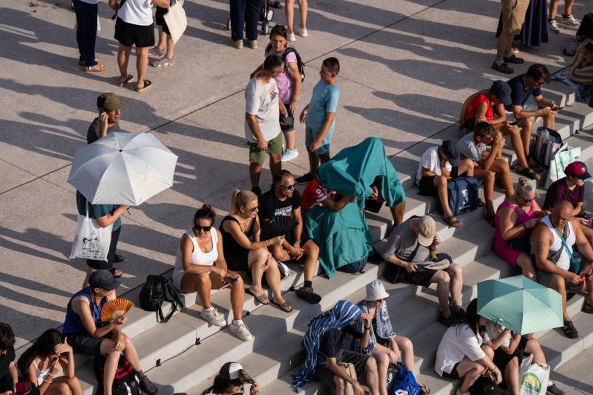 Visitantes y aficionados a la observación astronómica esperan en el Port de la Maria, en Tarragona, para contemplar el eclipse total de Sol.