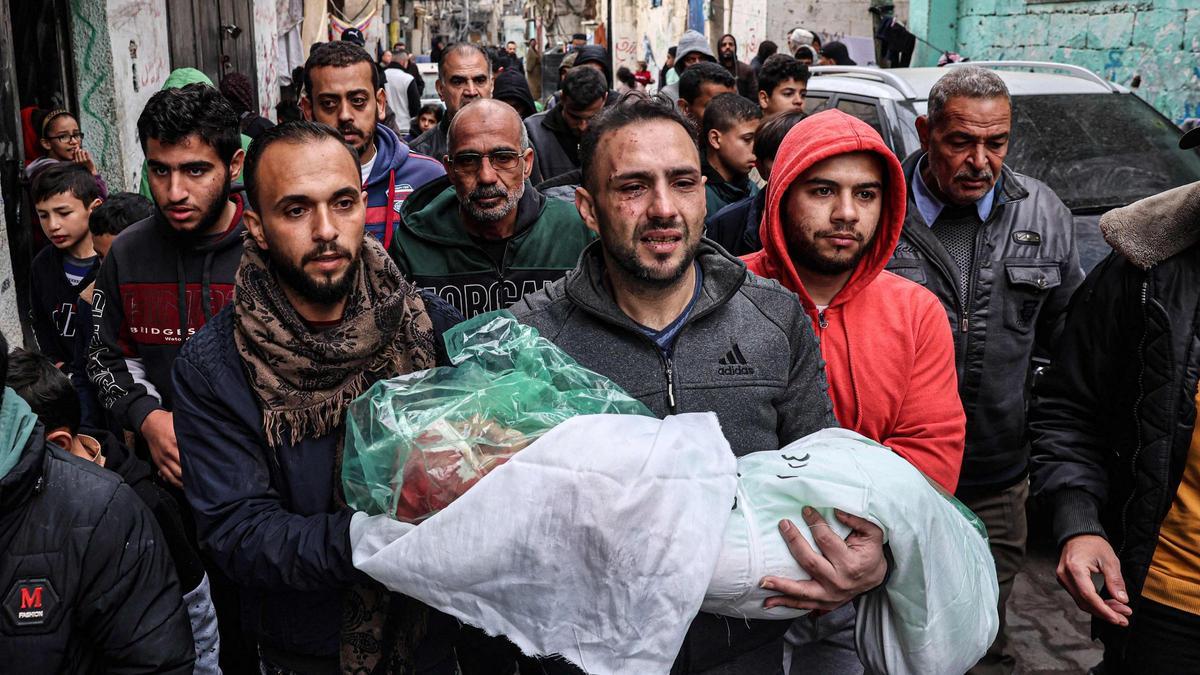 El padre de Masa Shoman lleva el cuerpo sin vida de su hija, muerta en un ataque israelí, durante su funeral en Rafah, en la Franja de Gaza
