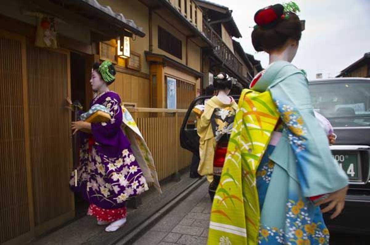 Tres geishas entrando en un taxi en el distrito de Gion.