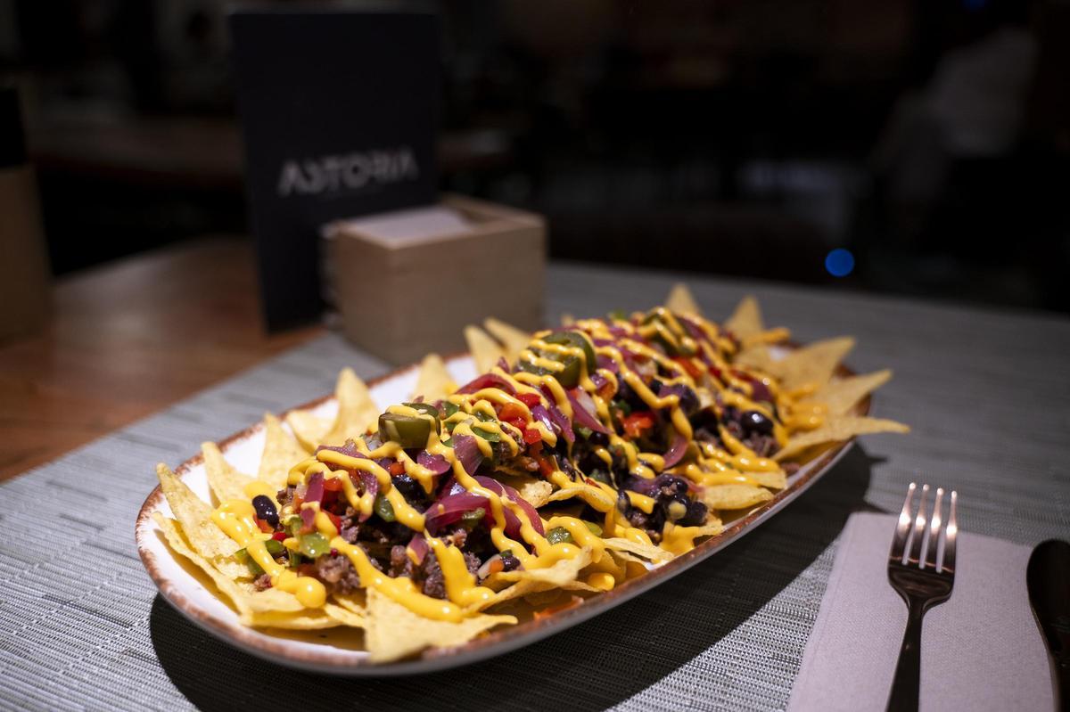 Nachos con alubias pintas, carne picada con verduras, totopos, pico de gallo y salsa cheddar.