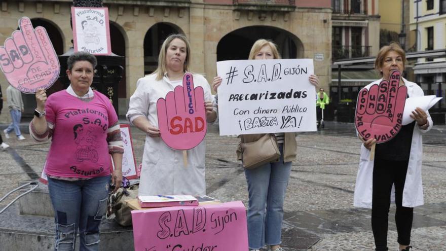 Por la izquierda, Josefina Fernández, Rocío Calvo, Herminia López y Susana Vázquez, ayer, en la plaza Mayor, con las pancartas. | Juan Plaza