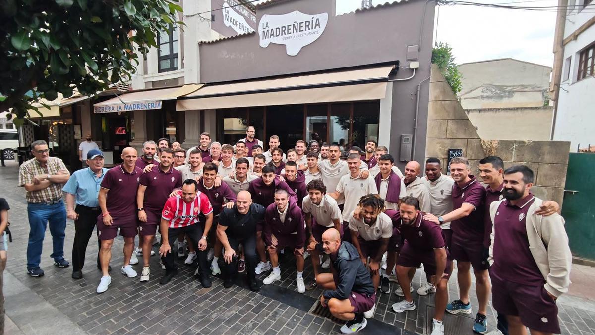 Jugadores y cuerpo técnico del Sporting delante de La Madreñería.