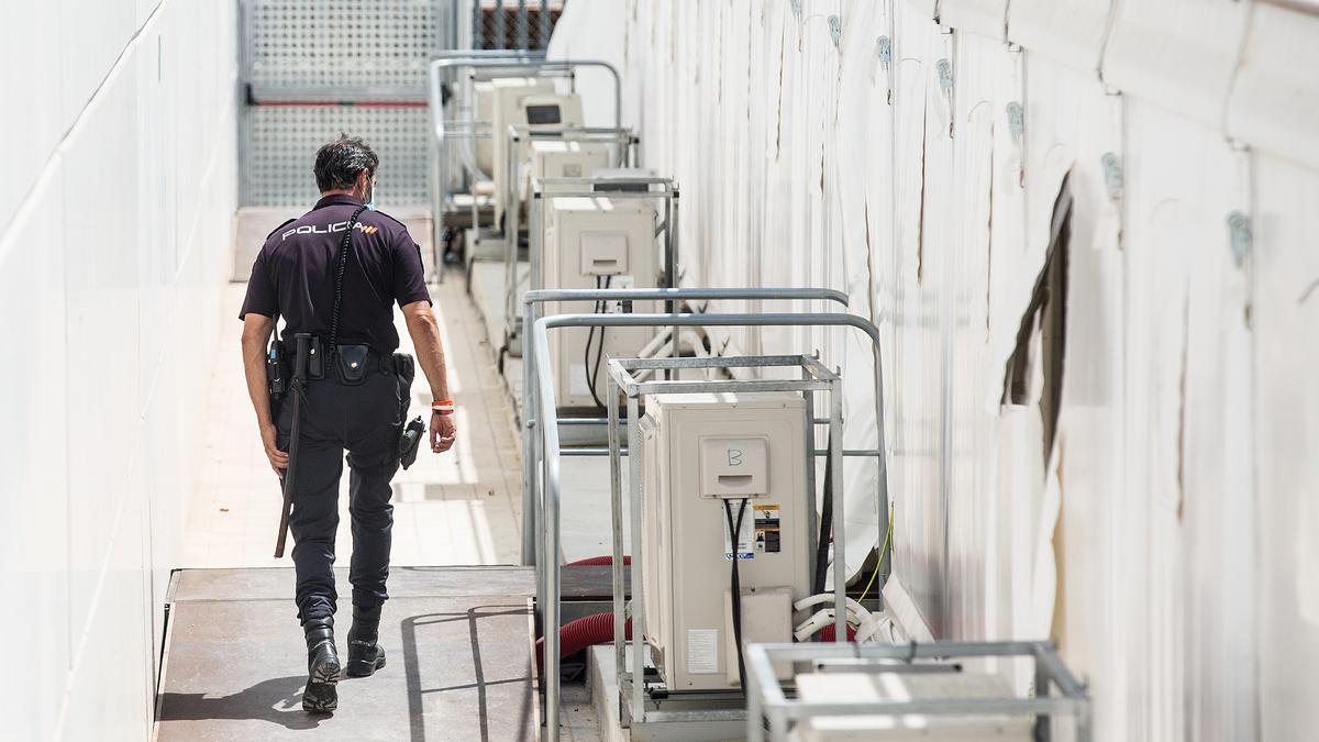 Un agente de la Policía Nacional en el hospital de campaña levantado en Alicante, que ha acogido desde el verano a inmigrantes llegados a las costas de la provincia.