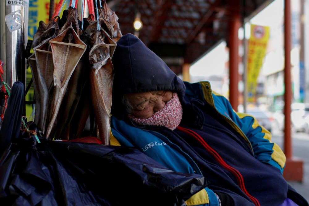A vendor sleeps in a local market in Gangneung