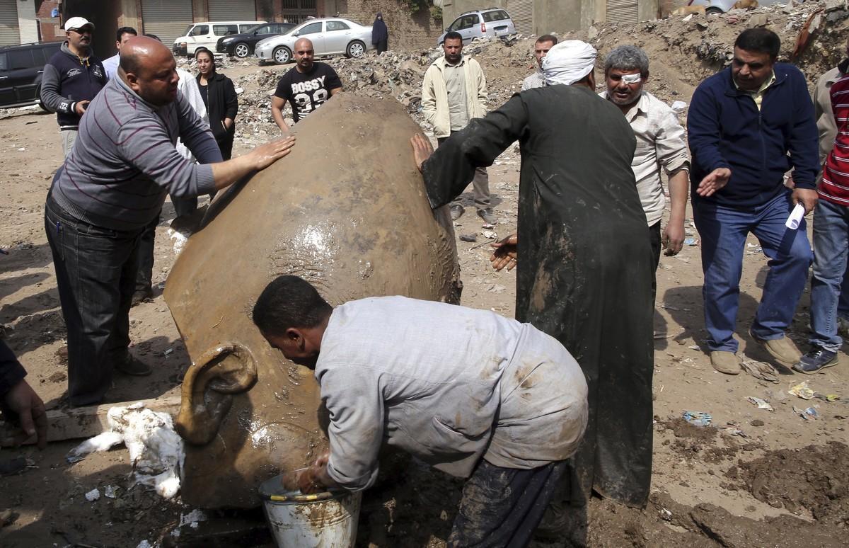 KEF03 EL CAIRO  EGIPTO  09 03 2017 - Varios trabajadores egipcios permanecen contra la parte de una estatua desenterrada en el barrio de Souq al Khamis  en El Cairo  Egipto  hoy  9 de marzo de 2017  Segun fuentes oficiales  se han encontrado dos partes de estatuas reales de la XIX dinastia en la entrada del templo del faraon Ramses II  EFE Khaled Elfiqi