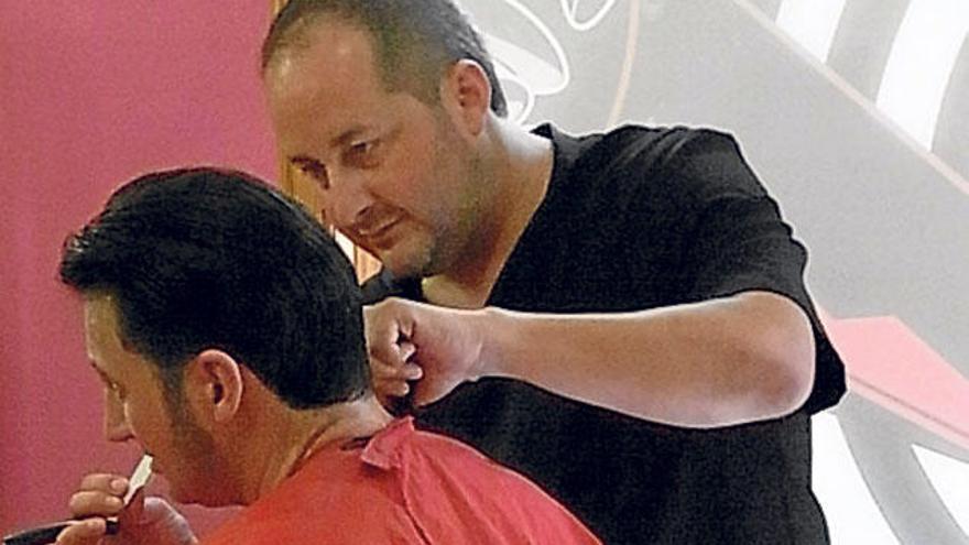 Jaume Pons atiende a un cliente en su barbería.