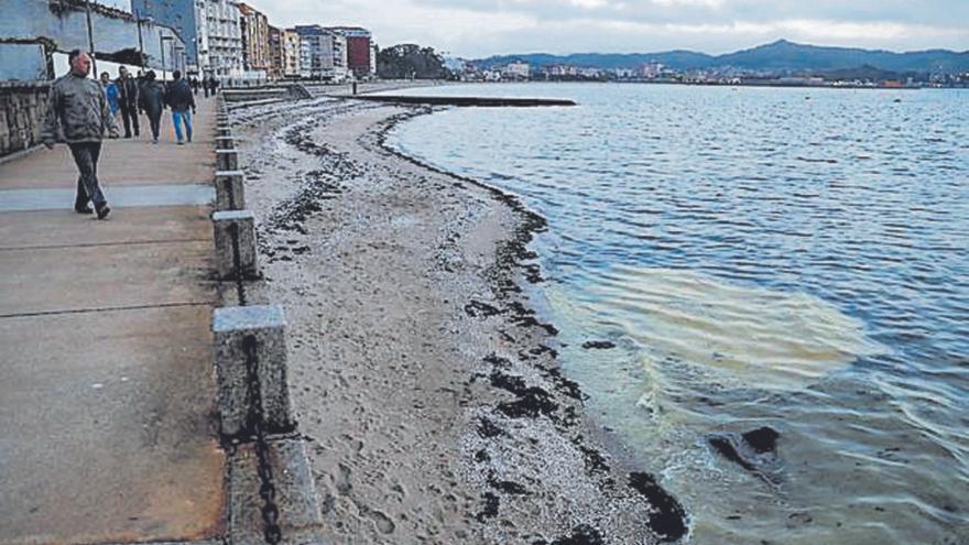 La retirada del fuel en la playa requirió el uso de barreras anticontaminación.   | // IÑAKI ABELLA