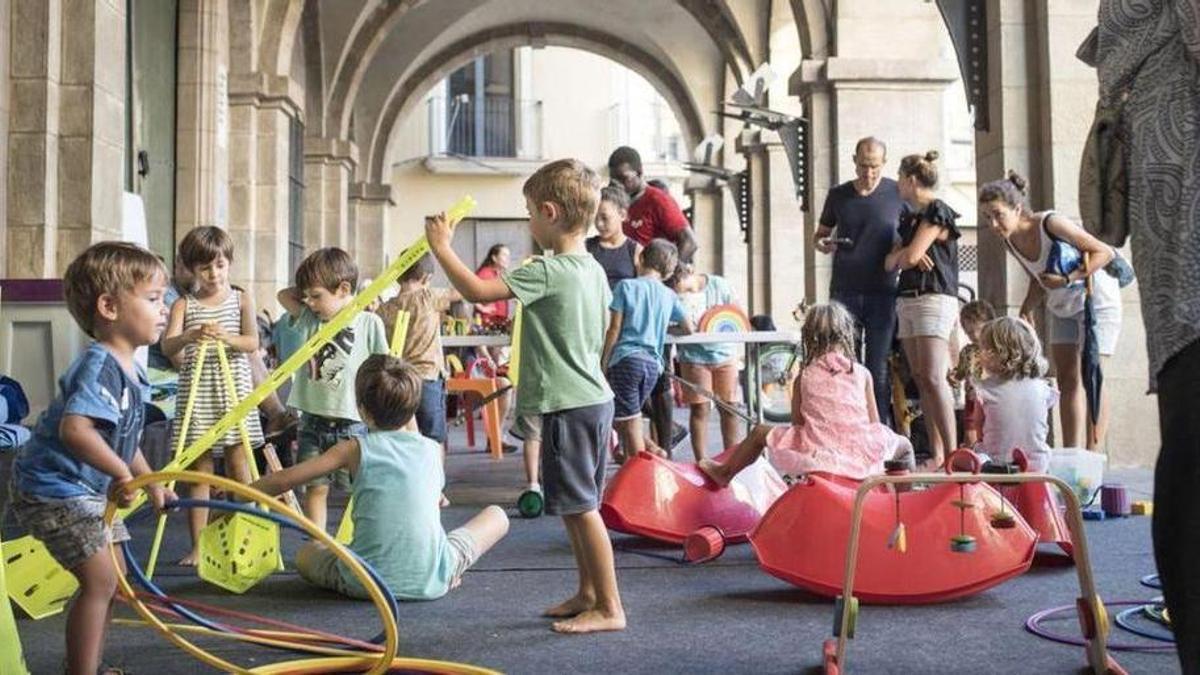 Infants jugant al porxo de la plaça Major de Manresa en la Setmana de Jocs al Carrer