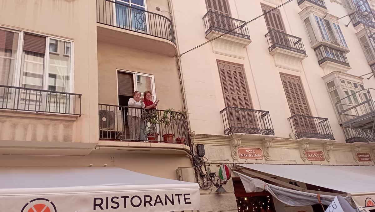 Dos vecinas de calle Alcazabilla aplauden al paso de la manifestación por la vivienda, el pasado sábado.