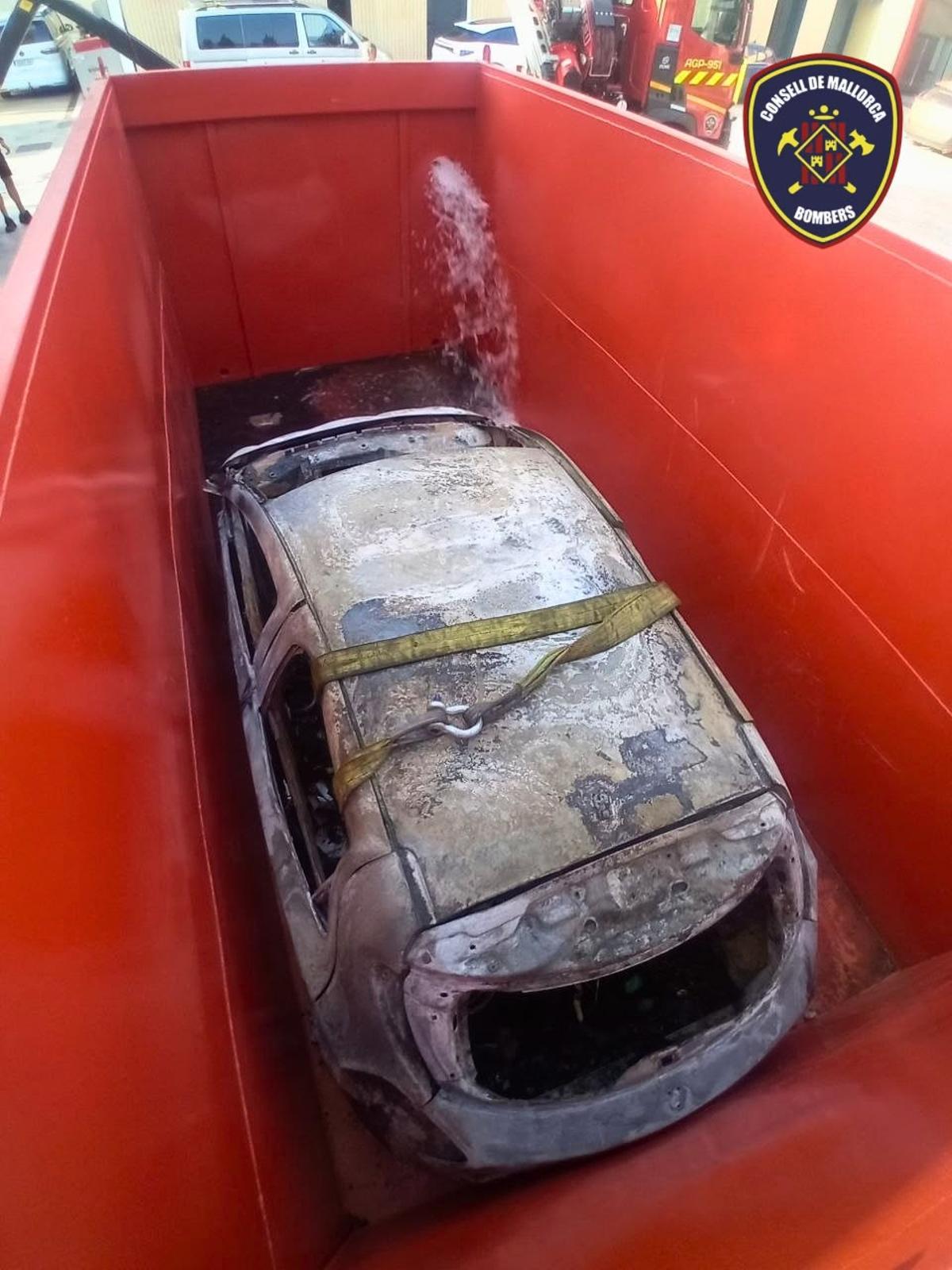 El coche eléctrico confinado en un contenedor antes de ser sumergido en agua para lograr su completa extinción.