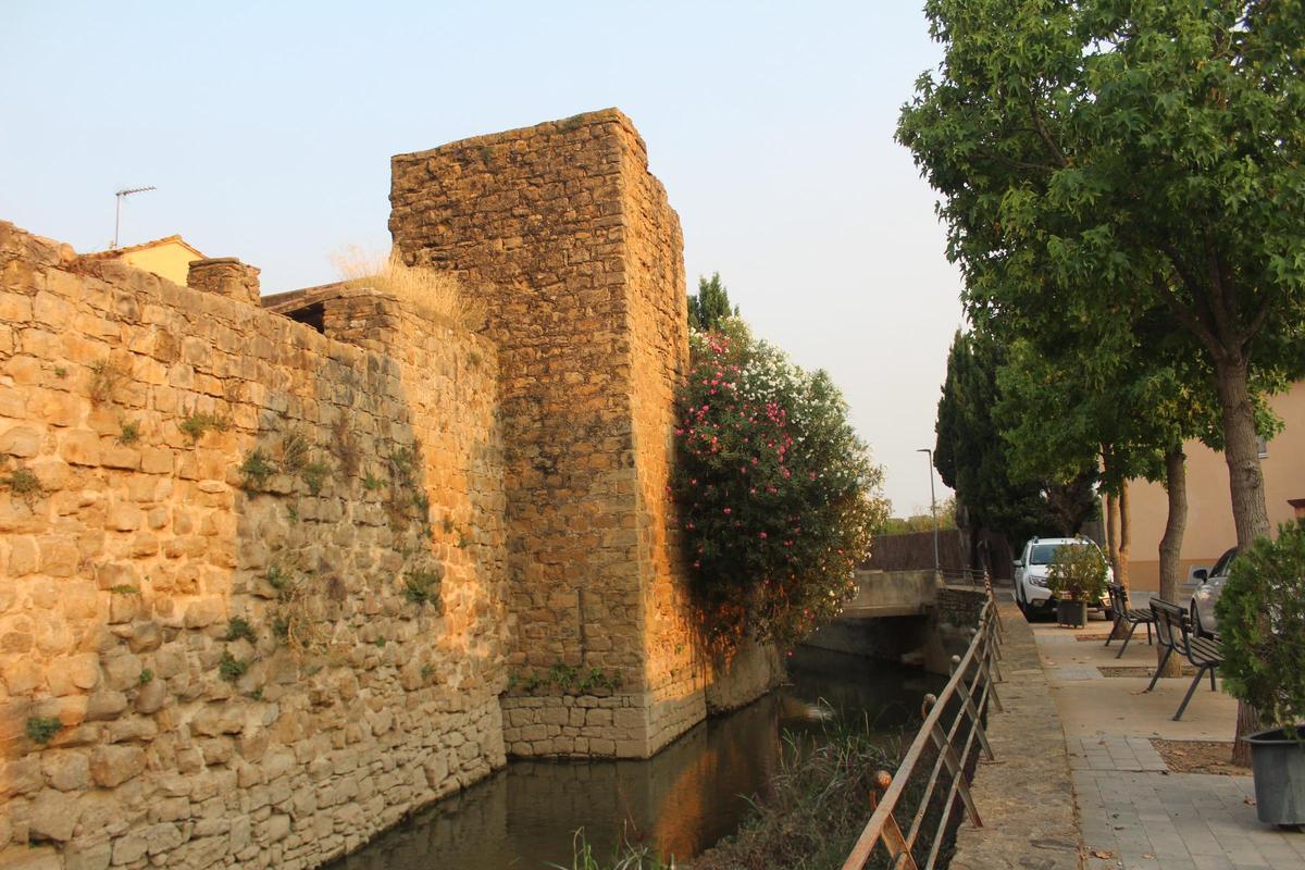 La muralla de Verges sobre el rec del Molí