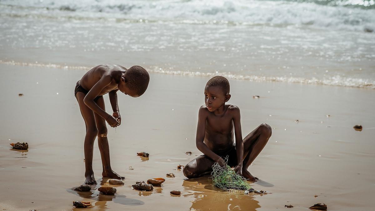 Dos nens busquen petxines a la platja del Senegal el 2014