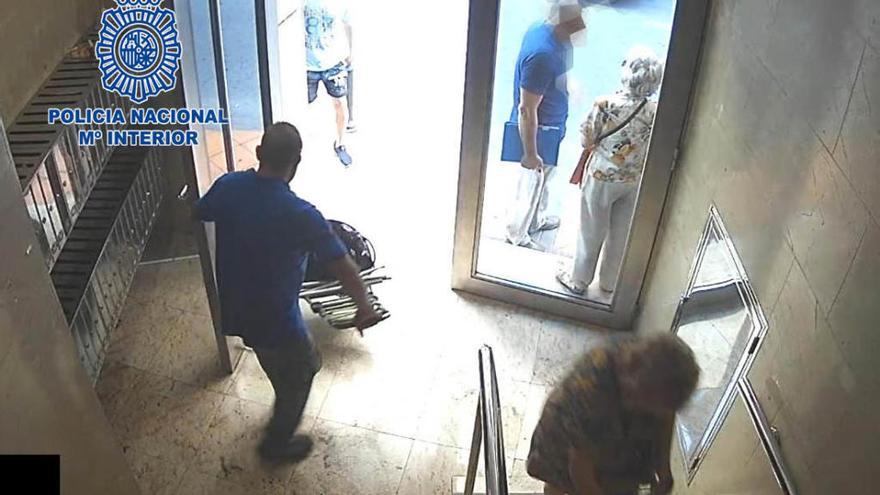 Uno de los detenidos a la espera de entrar al edificio y robar a la víctima (a la derecha)