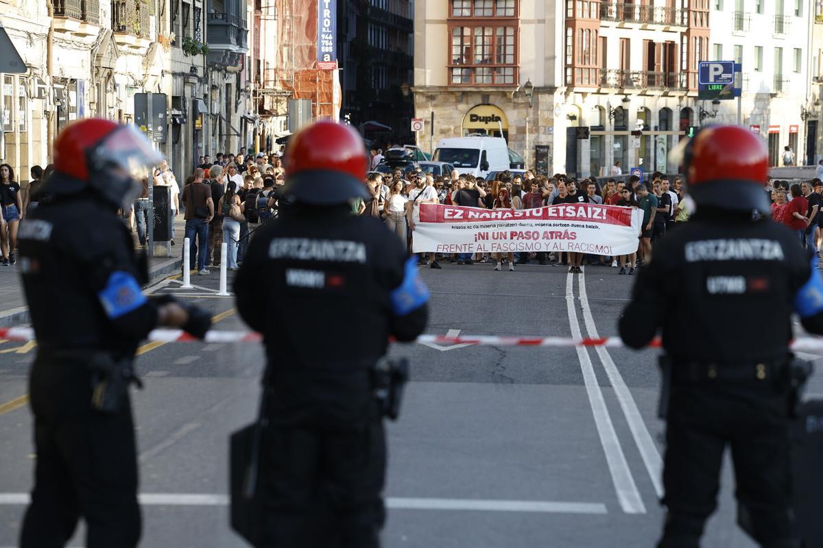 Un cordón policial formado por agentes de la Ertzaintza separa las dos manifestaciones de este miércoles en Bilbao entre miembros y simpatizantes de la organización juvenil comunista vasca Gazte Koordinadora Sozialista (GKS) y los grupos de extrema derecha,  por la situación en Ceuta.