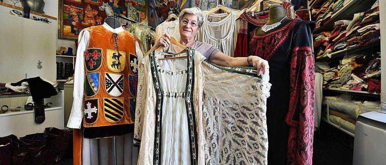 María del Carmen Rodiño en su taller con algunos de sus trajes.