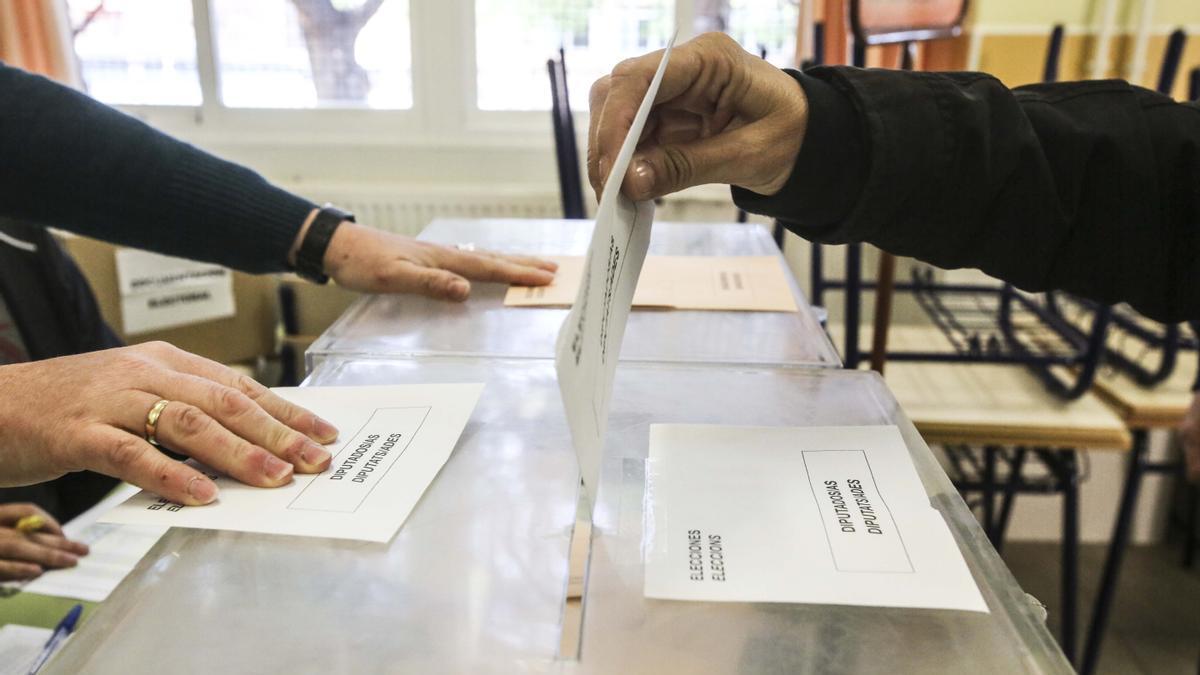 Una persona deposita su voto en las urnas