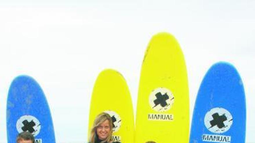 Cuatro de los alumnos de la escuela de surf tapiega posan junto a su monitor, Enrique Lombardía. / t. cascudo