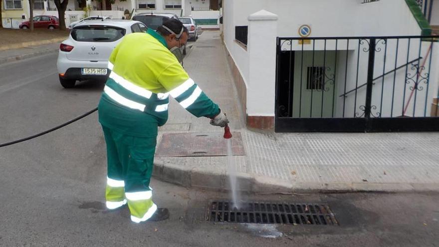 Un trabajado de Hidrogea fumigano una trampilla.