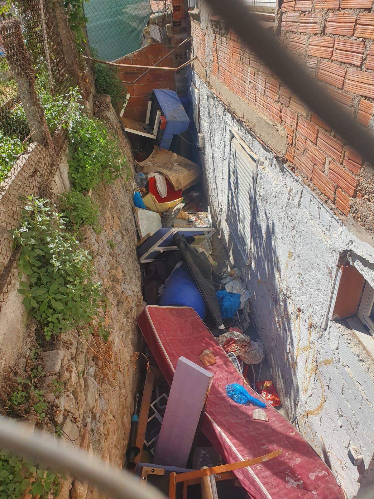 Brutícia llançada a l'espai que queda entre dues cases al carrer d'Aiguader