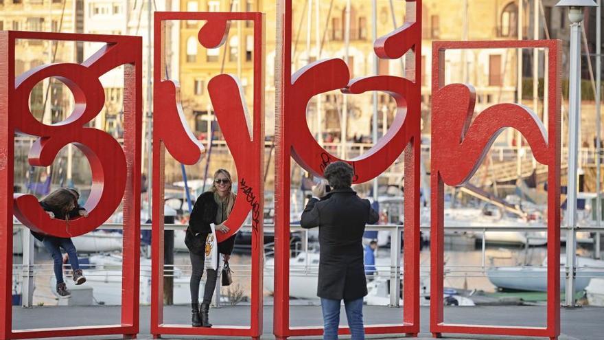 Turistas se hacen una foto en las &quot;letronas&quot; del muelle de Gijón.