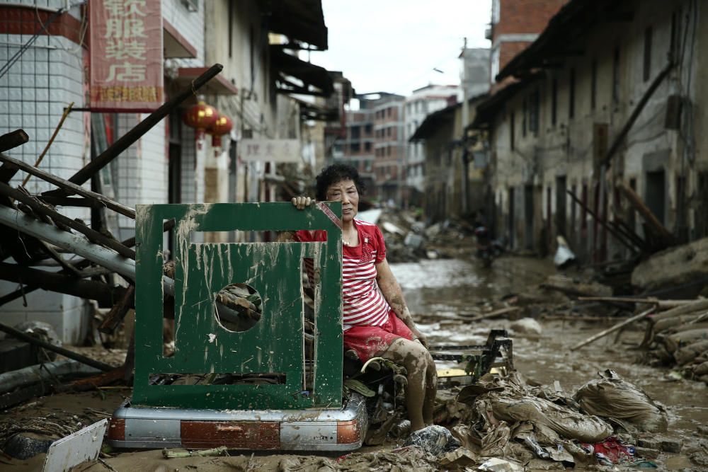 Una mujer sentada rodeada por las ruinas provocadas por el tifón Nepartak en la provincia de Fujian, China.