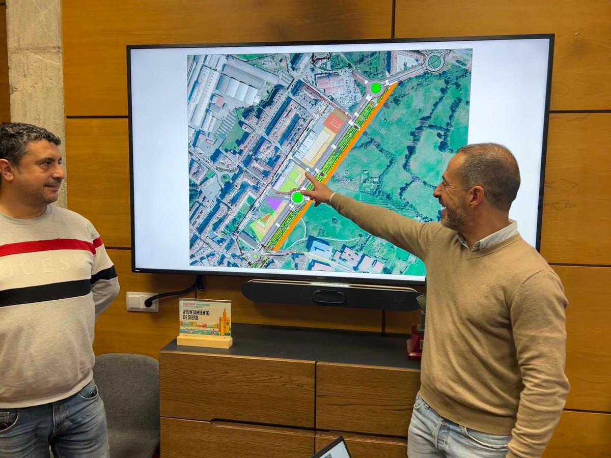 El alcalde de Siero, Ángel García "Cepi", señala la zona donde se construirán las primeras viviendas del bulevar de Lugones, junto a Javier Rodríguez, concejal de Urbanismo.