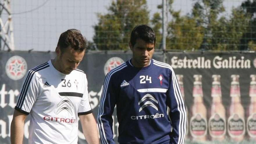 Augusto camina pensativo con uno de los recuperadores del Celta, ayer en A Madroa.  // De Arcos