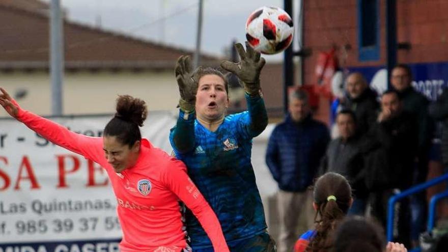 La portera Eva trata de hacerse con el balón ante la presencia de una jugadora del Friol.