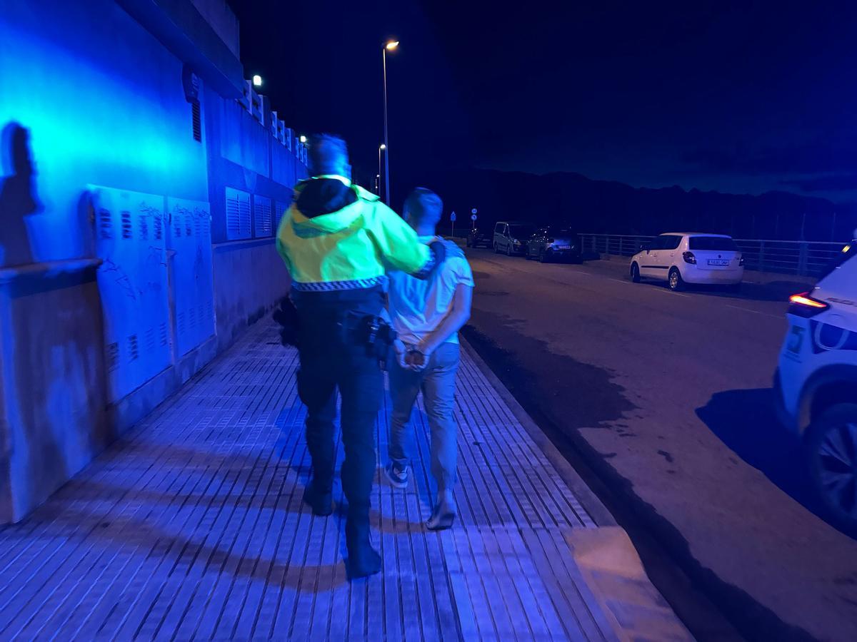 Uno de los arrestados, con un agente
