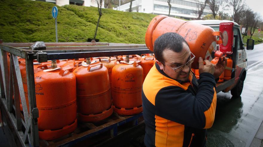 Archivo - Un repartidor de bombonas de butano carga con una bombona