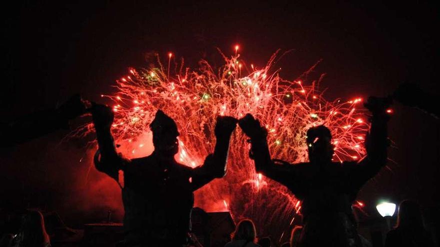 Los fuegos artificiales en Les Campes, tras la silueta del &quot;Monumento al Carmín&quot;.