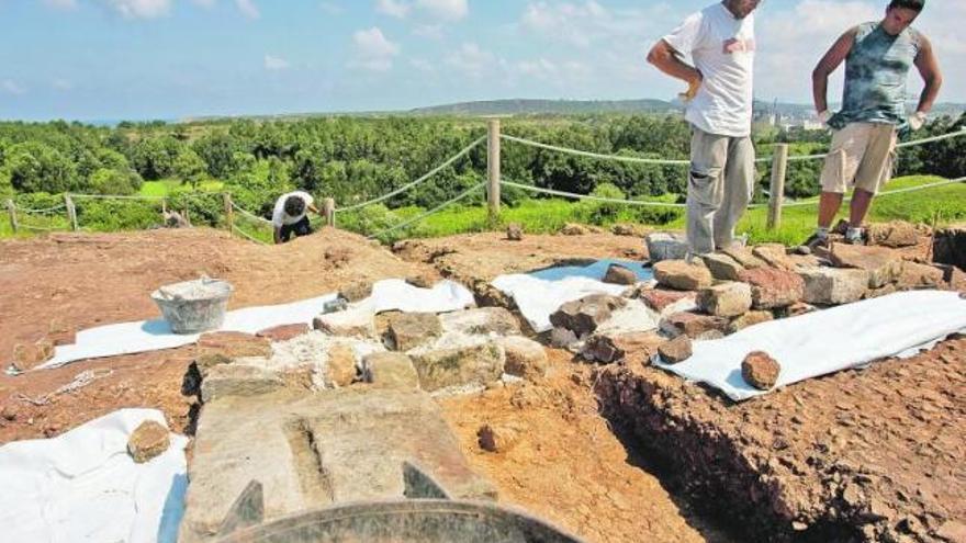 A la izquierda, Alejandro García, con otro miembro del equipo, en el yacimiento arqueológico del castillo de Gauzón, el viernes.