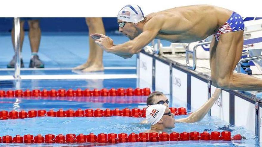 Phelps se lanza a la piscina durante un entrenamiento. // Efe