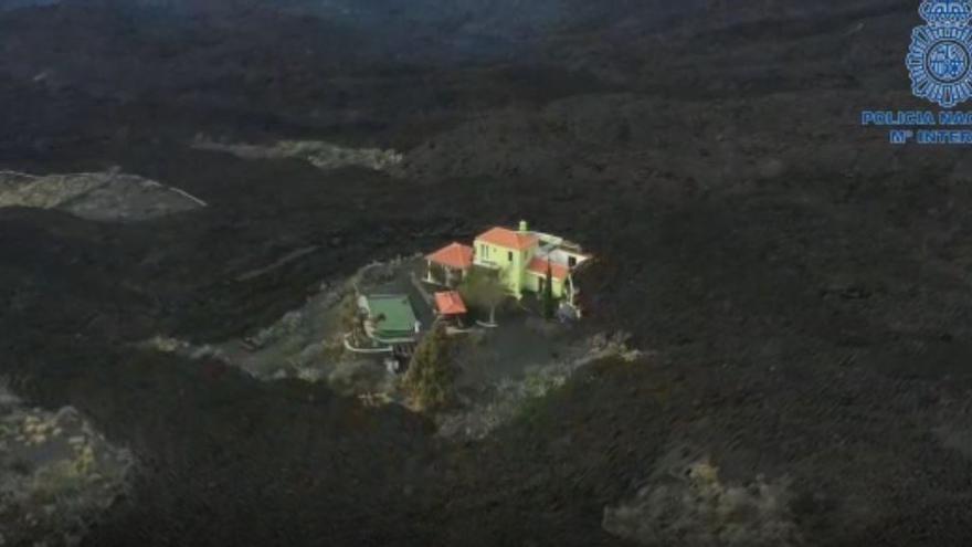 La lava rodea una de las viviendas próximas al volcán de La Palma.