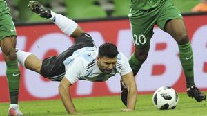 Agüero cae al suelo ante dos jugadores de Nigeria.