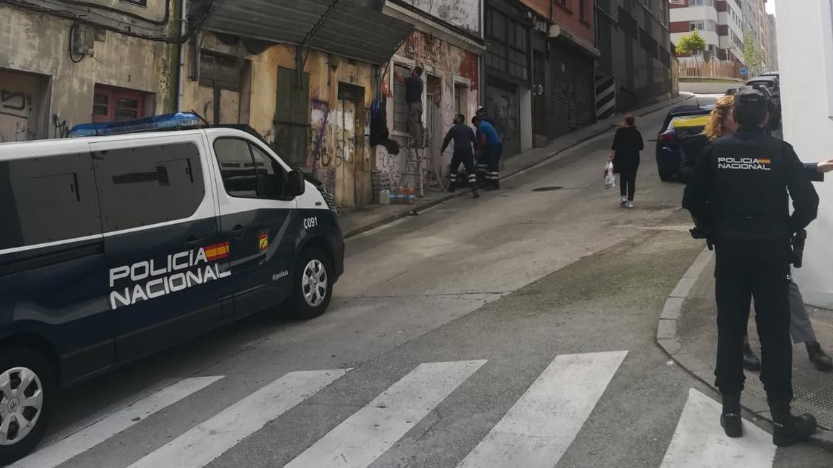 Un grupo de operarios tapian la entrada al edificio desalojado en Travesía de la Cerca.