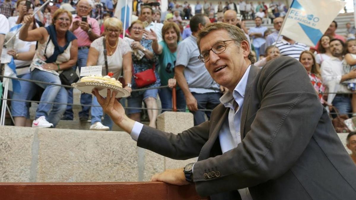 Alberto Núñez Feijóo saluda a varios simpatizantes, el sábado, que le regalaron una tarta por su cumpleaños.