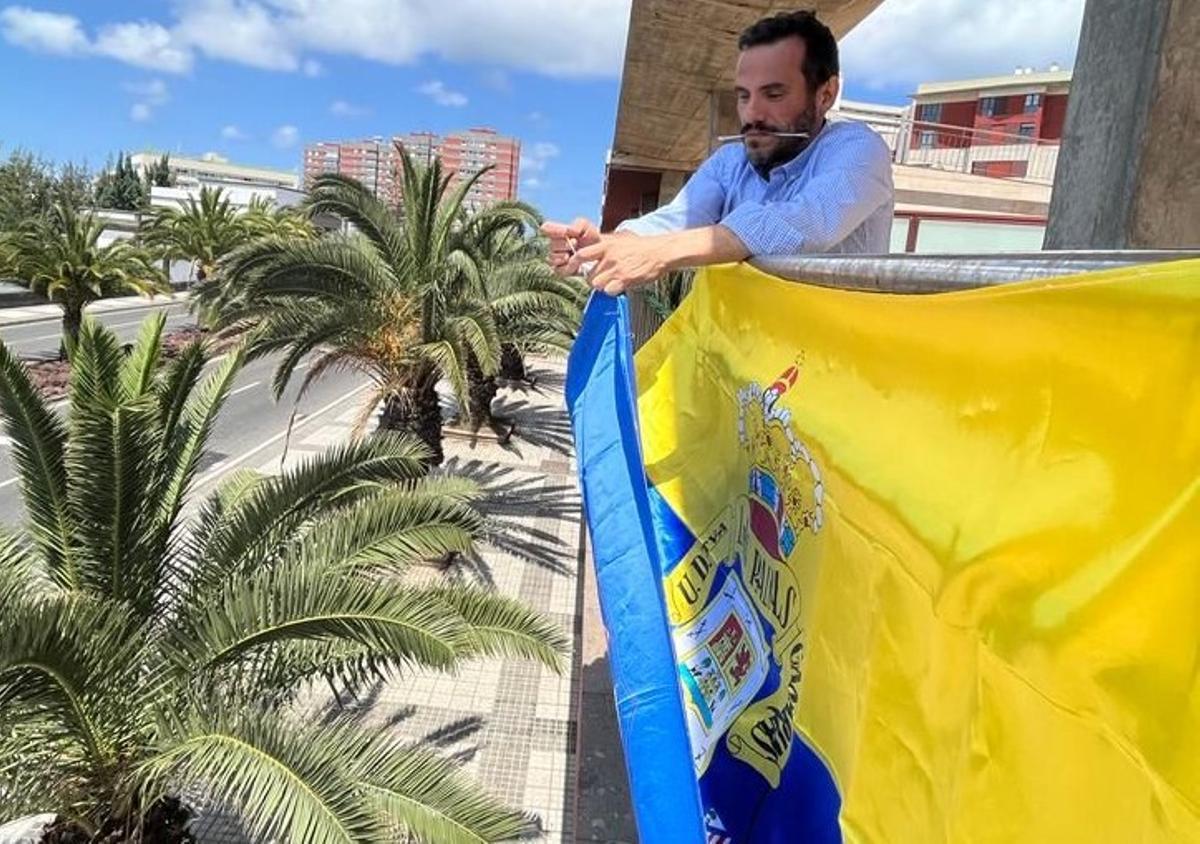 Rubén Fontes, delegado de la UD, colocando la bandera de Las Palmas en el barrio de La Minilla.