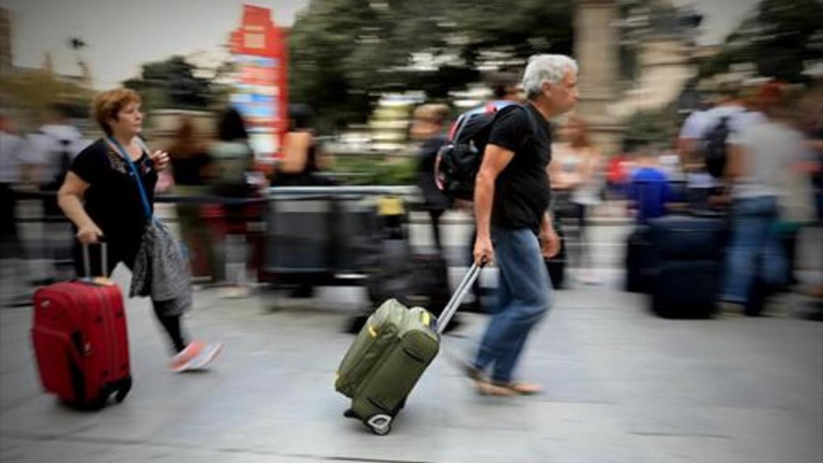 Viajeros 8Una pareja con sus maletas y mochilas, ayer en una calle de Barcelona.