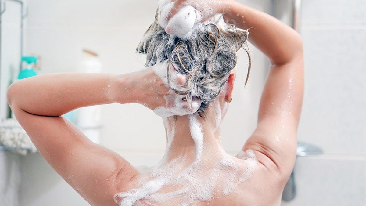 Chica lavándandose el pelo