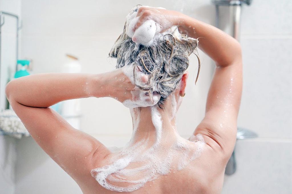 Chica lavándandose el pelo