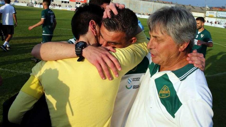 Jacobo Montes, entrenador del Coruxo, se abraza con David Campos y Manuel Prado. // Marta G. Brea