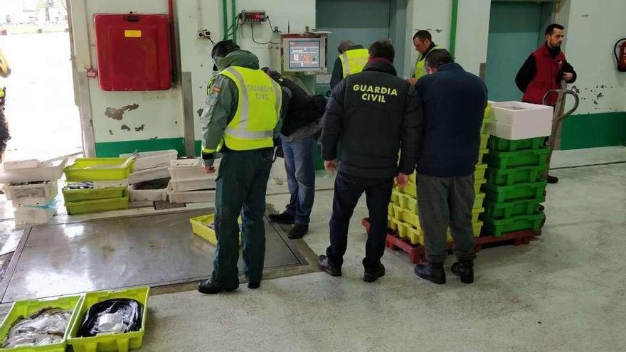 Los agentes de la Guardia Civil en el momento del pesaje de la mercancía, ayer, en la lonja de A Coruña.