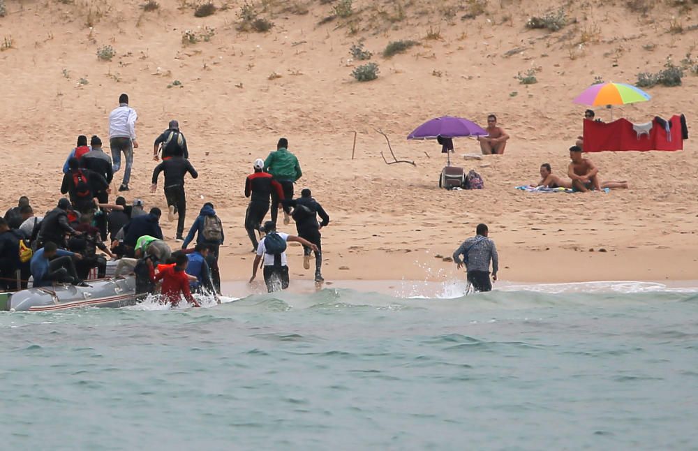 Una patera llega a una playa de Cádiz ante la mirada de los bañistas