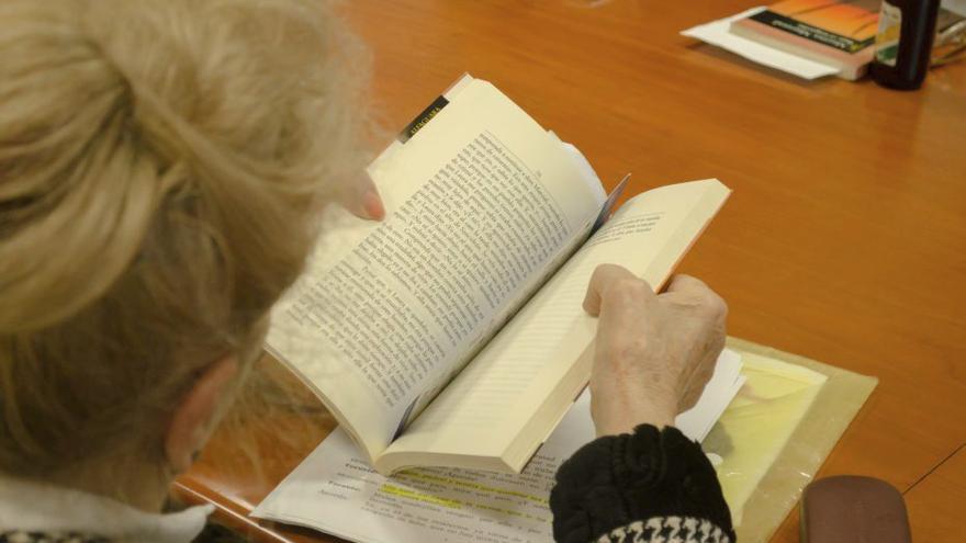 Una jubilada leyendo un libro.