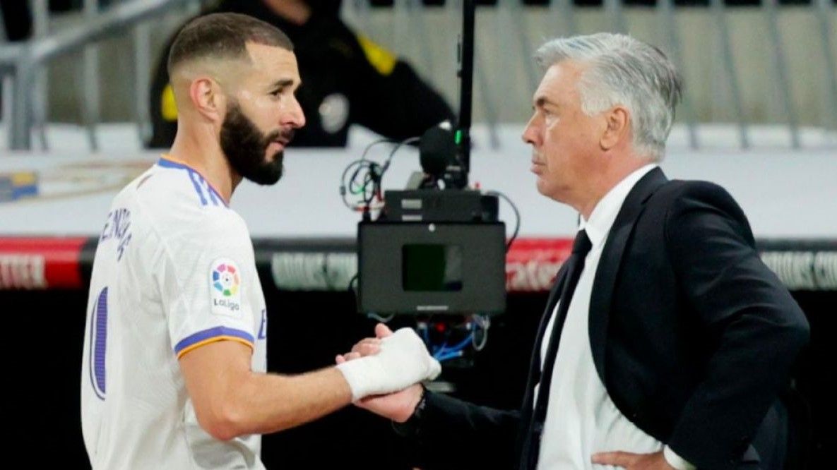 Benzema y Ancelotti se saludan en un partido.