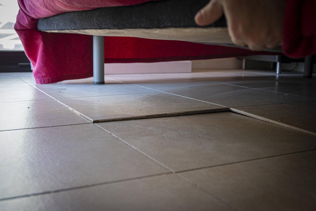 Baldosas desencajadas en una vivienda que reclama compensaciones por presuntos daños por las obras del Camp Nou, en Barcelona.