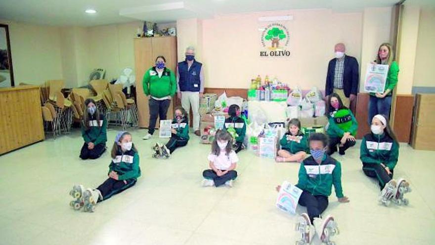 Acto de entrega de los alimentos, con patinadores del club.