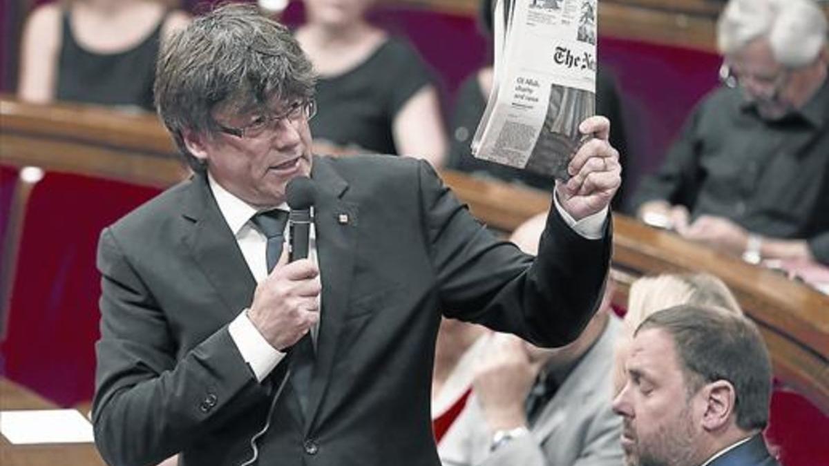 Puigdemont muestra un ejemplar de 'The New York Times' en el Parlament.
