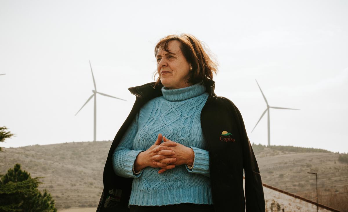La alcaldesa de Suellacabras, María Felicidad Gómez Lafuente, posa con los molinos de viento al fondo. 